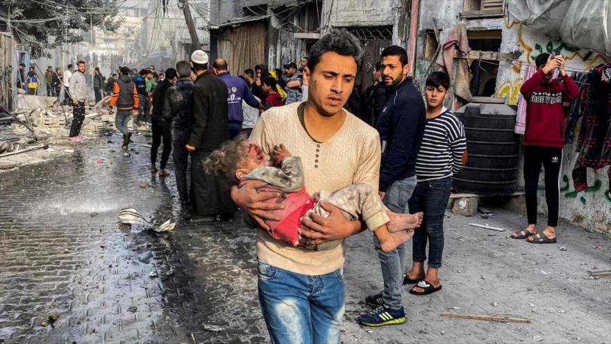 Un hombre traslada a una niña herida en los ataques israelíes en Rafah, en el sur de la Franja de Gaza, 1 de diciembre de 2023.