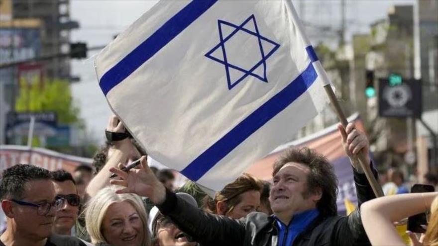 El presidente electo de Argentina, Javier Milei, enarbola una bandera israelí, tras conocer su triunfo electoral.