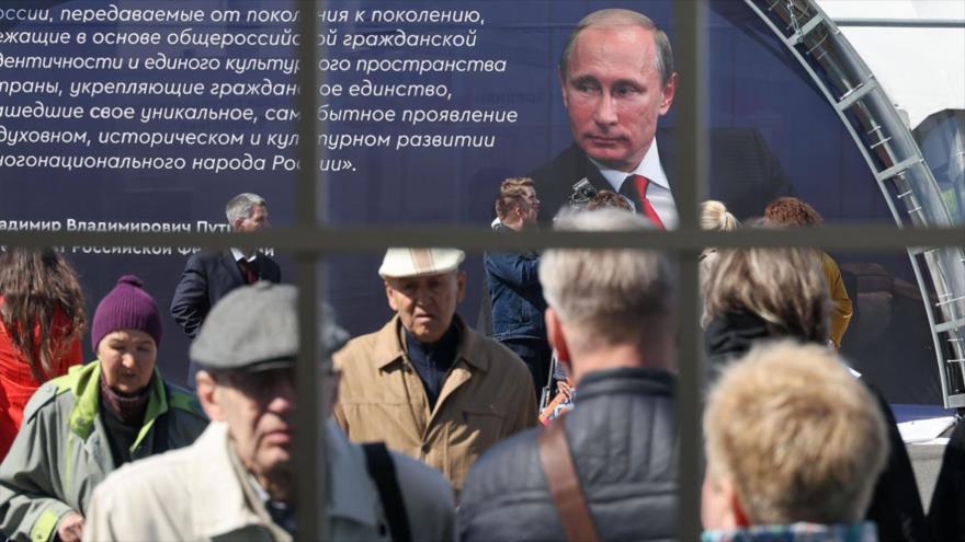 Una foto del presidente ruso Vladimír Putin en la plaza del Palacio de San Petersburgo.