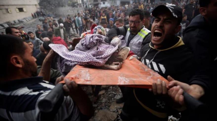 Palestinos cargan a una niña muerta, encontrada bajo los escombros de un edificio destruido tras los ataques aéreos israelíes. 