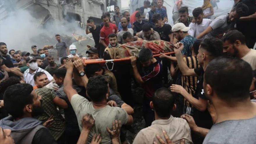 Palestinos retiran un cadáver de los escombros de un edificio después de un ataque aéreo israelí en el campo de refugiados de Yabalia, Gaza. 