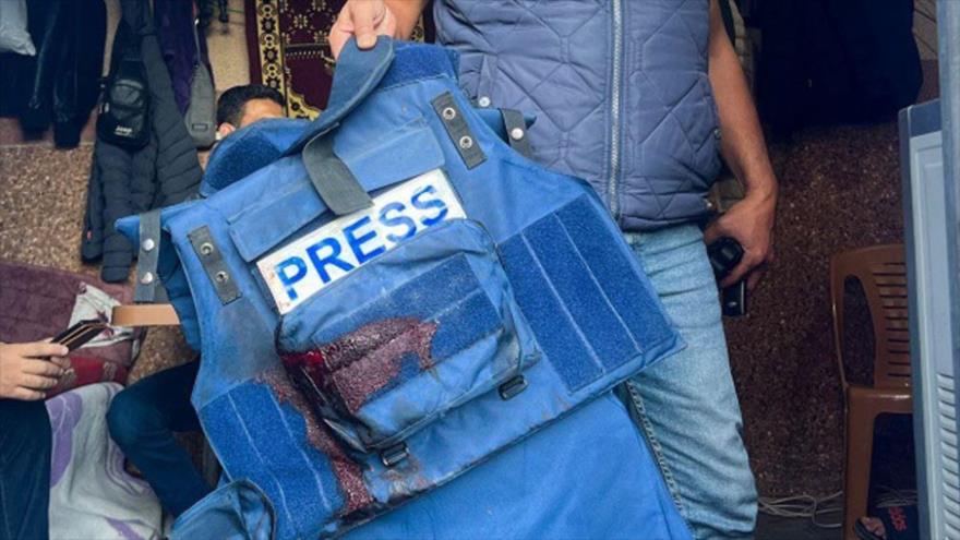 Un hombre sostiene el chaleco de prensa del corresponsal de Al Jazeera, Wael Al-Dahdouh, herido en un ataque israelí en Jan Yunis, Gaza, 15 de diciembre de 2023.