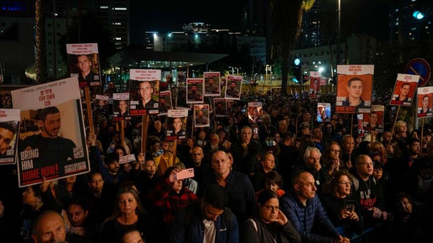 Manifestantes sostienen pancartas con imágenes de israelíes retenidos en Gaza y piden la destitución de Netanyahu, 30 de diciembre de 2023.