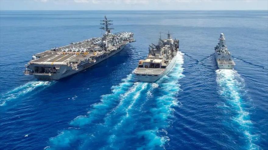 El portaviones USS Dwight D. Eisenhower de la Marina de EE.UU. (izqda.) navega en el océano Atlántico, 3 de julio de 2023.