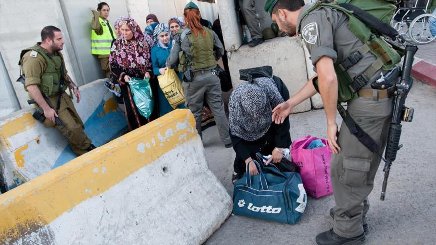 Fuerzas israelíes confiscan las bolsas de los palestinos desplazados en un puesto de control en Gaza.