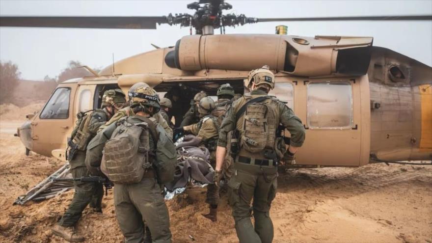 Soldados israelíes evacuan a un colega herido a un helicóptero militar en las afueras de la frontera de Gaza.