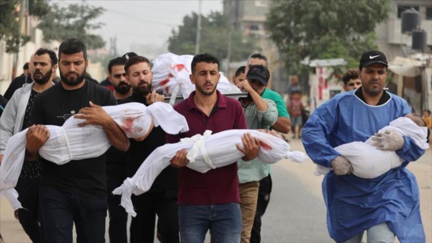 Hombres palestinos transportan a civiles (incluidos niños envueltos en ropa blanca) muertos por los ataques israelíes a Gaza, octubre de 2023. (Foto: Getty Images)