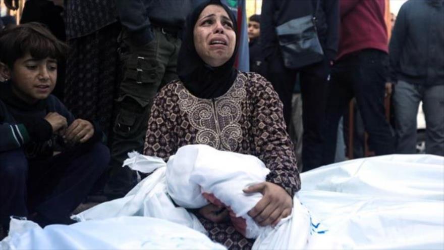 Mujer palestina sostiene el cuerpo de su hijo asesinado en los bombardeos israelíes contrala Franja de Gaza.