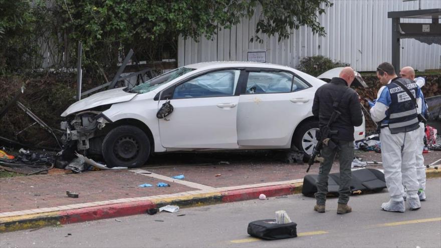 Militares israelíes inspeccionan un automóvil dañado tras un presunto ataque en la ciudad de Raanana, 15 de enero de 2024. 
