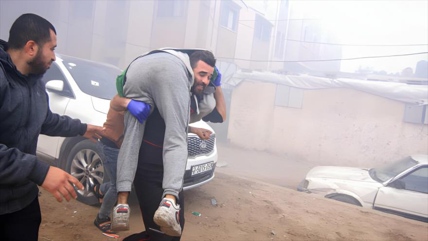 Un hombre lleva a un palestino herido de un ataque aéreo israelí contra un edificio residencial al oeste del Hospital Médico Nasser en Jan Yunis, 11 de enero de 2024. 