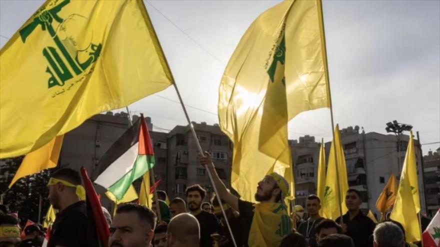 Un grupo de personas con banderas de Hezbolá en la capital de Líbano, Beirut, durante un discurso televisado del líder del grupo.