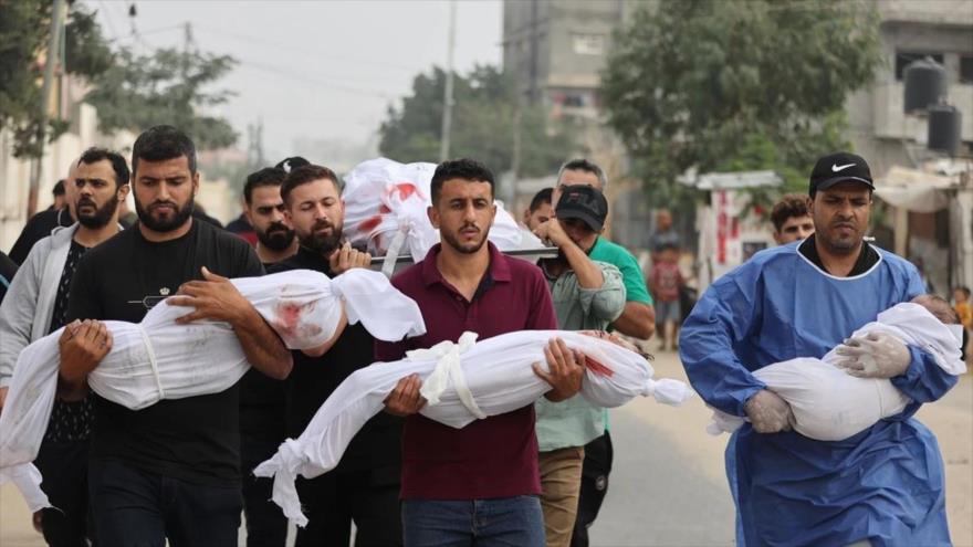 Cargan los cuerpos del padre y los tres hijos de la familia Al Zinaty que murieron en un ataque israelí en Jan Yunis, 23 de octubre de 2023. (Foto: Getty Images)