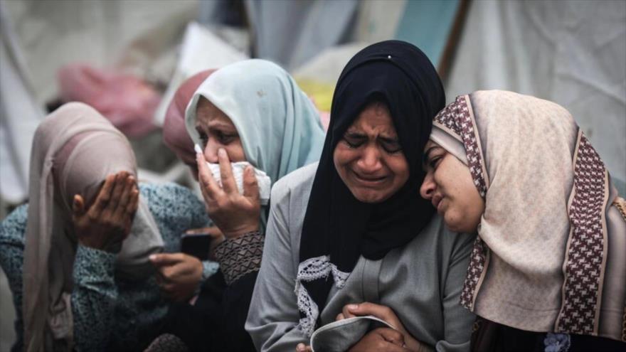 Palestinos lloran a sus familiares muertos en un ataque contra el campo de refugiados de Al-Maqazi, en la Franja de Gaza, 25 de diciembre de 2023.