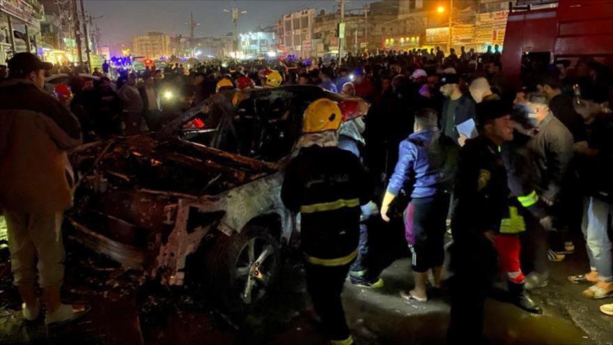 Ciudadanos iraquíes cerca del vehículo destruido por ataque de EE.UU. en Bagdad, 7 de febrero de 2024. (Foto: Reuters)