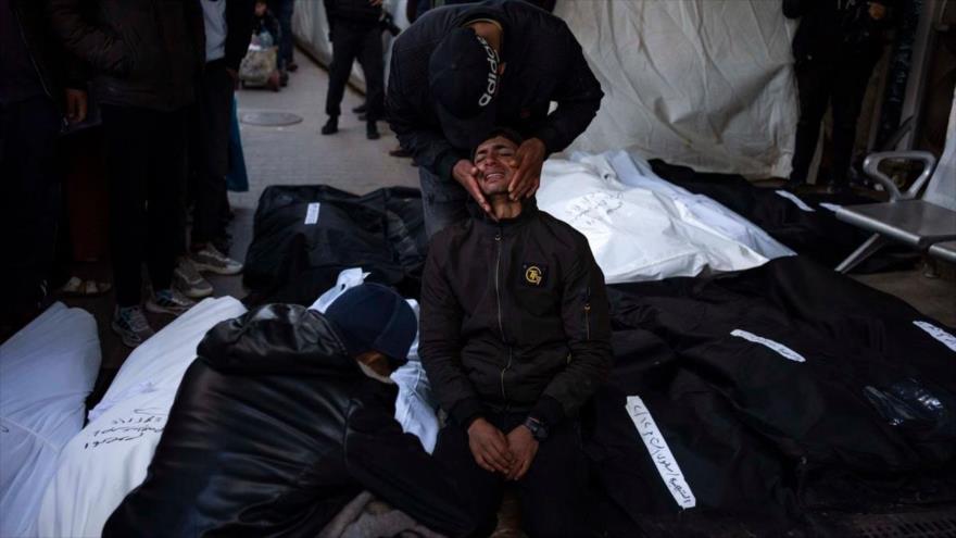 Varios palestinos lloran por la muerte de sus familiares durante un bombardeo israelí en Rafah, 12 de febrero de 2024.