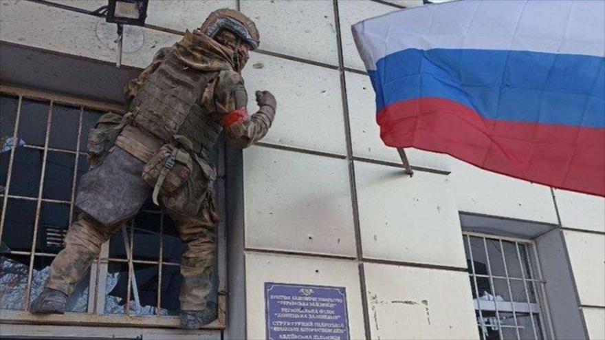 Soldado iza bandera rusa en un edificio de Avdiivka, en el este de Ucrania.