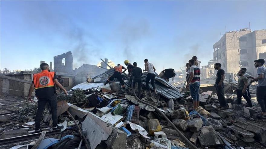 Civiles palestinos revisan los escombros generados tras un ataque israelí a Gaza.