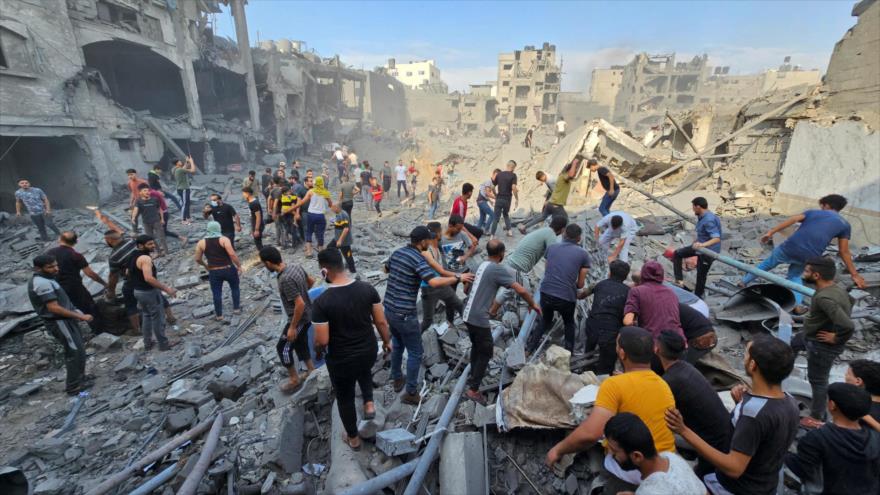 Los palestinos buscan cuerpos debajo de las ruinas de los edificios en Gaza.