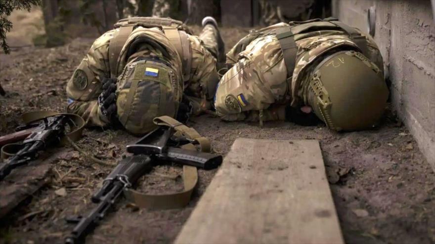 Soldados ucranianos se ponen a cubierto del fuego de artillería en las afueras de Kiev, 13 de marzo de 2022. (Foto: AP)