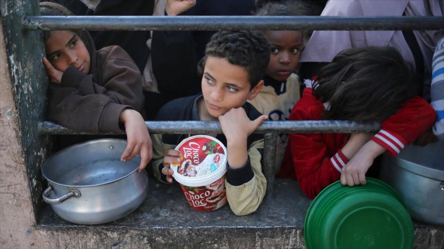 Palestinos esperan en fila para recibir alimentos antes del iftar (ruptura del ayuno) en el primer día del ramadán, en Rafah, 11 de marzo de 2024.