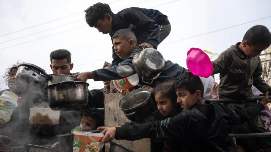 Niños palestinos esperan recibir comida en una cocina benéfica en medio de escasez de alimentos en Rafah. (Foto: AP)