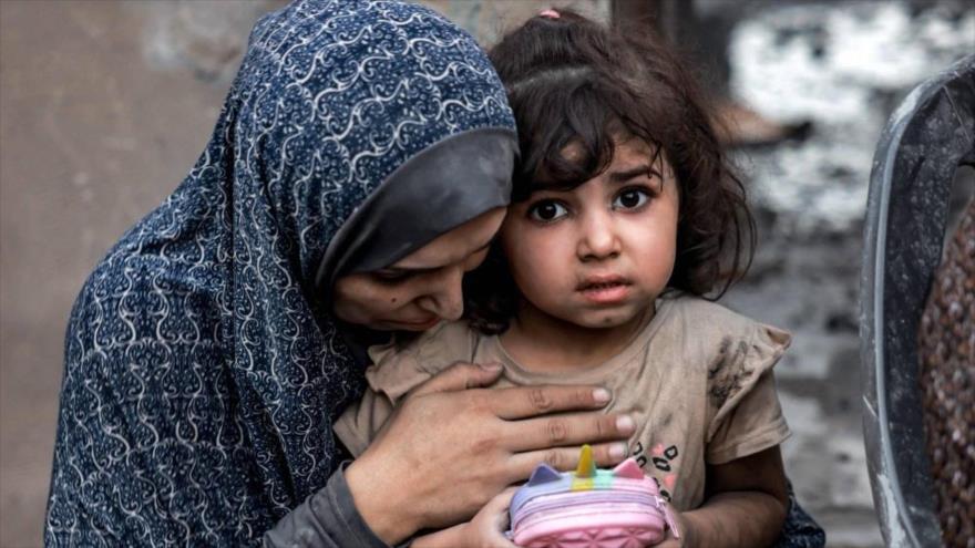 Una madre palestina y su niña sentadas cerca de casas destruidas tras un ataque en Rafah, en el sur de la Franja de Gaza, 11 de marzo.