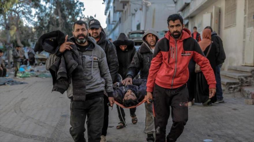 Palestinos transportan el cuerpo de un familiar muerto en un bombardeo israelí desde la morgue del hospital Al-Shifa en la ciudad de Gaza, 21 marzo de 2024. (Foto: AFP)