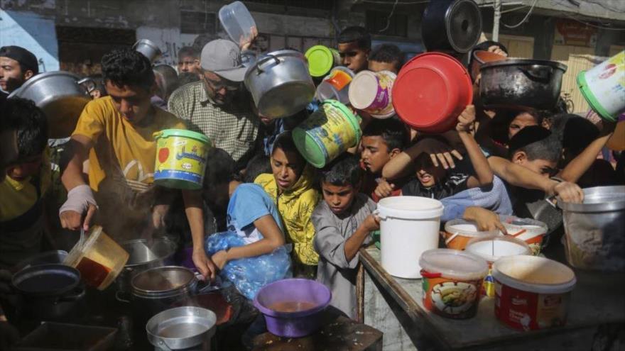 Palestinos se arremolinan mientras esperan la distribución de alimentos en Rafah, en el sur de la Franja de Gaza.