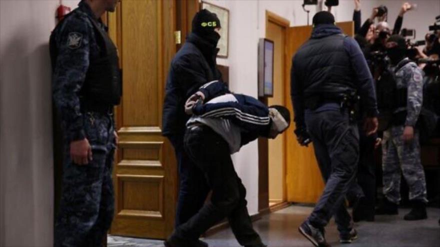 Agentes rusos llevan a un sospechoso implicado en el ataque a la sala de conciertos antes de su audiencia en un tribunal en Moscú, 24 de marzo de 2024. (Foto: AFP)
