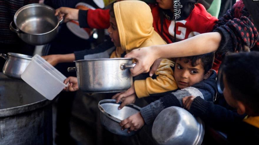 Niños palestinos esperan recibir comida en medio de escasez de alimentos en Rafah, en el sur de la Franja de Gaza, 5 de marzo de 2024.