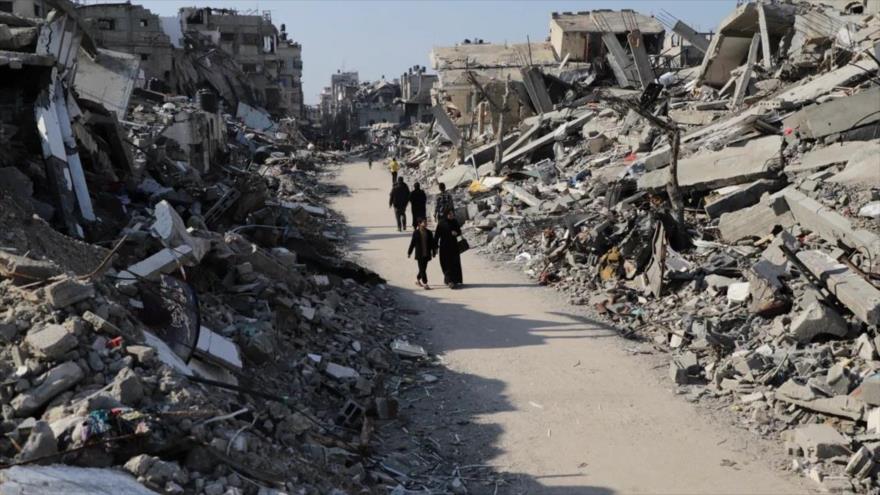 Los palestinos caminan entre la destrucción causada por la ofensiva israelí en el campo de refugiados de Yabaliya en Gaza, 29 de febrero de 2024. (Foto: AP)