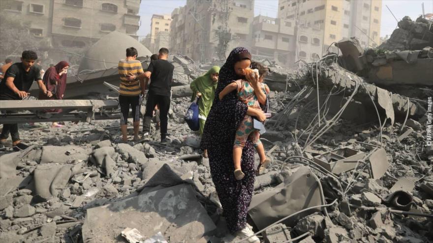 Palestinos sobre escombros de viviendas destruidas en agresiones israelíes en la Franja de Gaza.