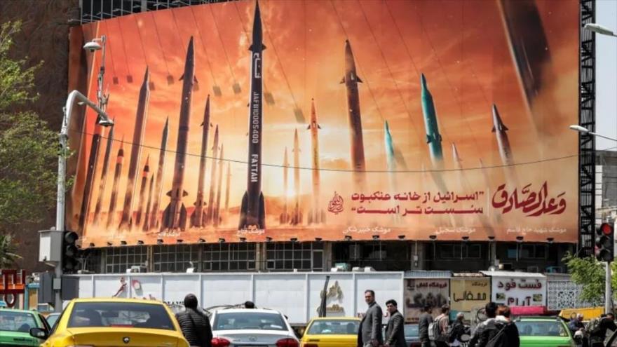 Un cartel que representa misiles balísticos iraníes, con un texto que dice “Israel es más débil que una telaraña”, en Teherán, 15 de abril de 2024. (Foto: AFP)