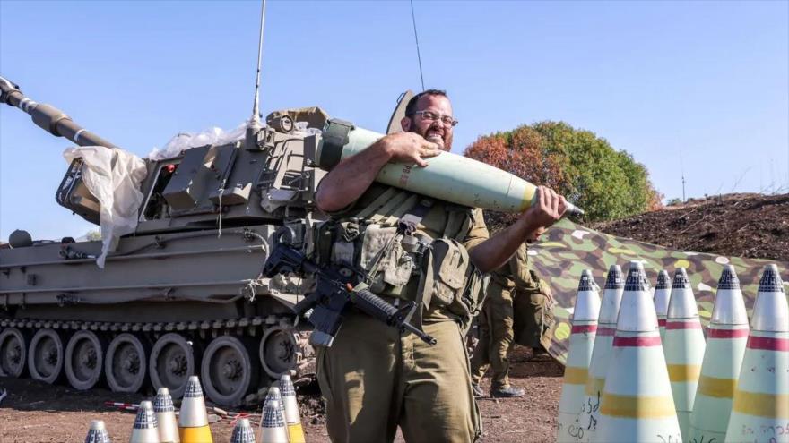 Un soldado israelí mueve un proyectil de artillería de 155 mm en un sitio cerca de la frontera con El Líbano, 18 de octubre de 2023. (Foto: AFP)
