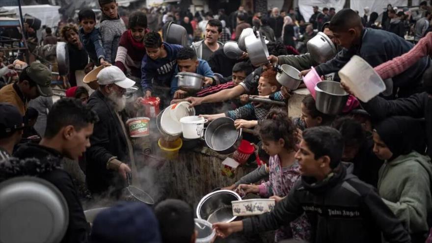 Palestinos haciendo cola para recoger alimentos en Rafah, sur de Gaza, en diciembre de 2023. (Foto: AP)
