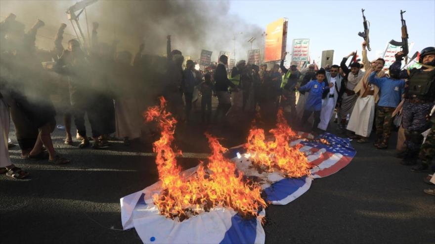 Los manifestantes en Yemen queman banderas de EEUU y de Israel en protesta por los ataques contra Yemen. 