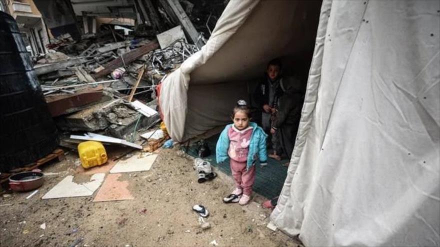 Una familia palestina vive en una tienda de campaña entre los escombros de su casa destruida en un ataque israelí en Rafah.