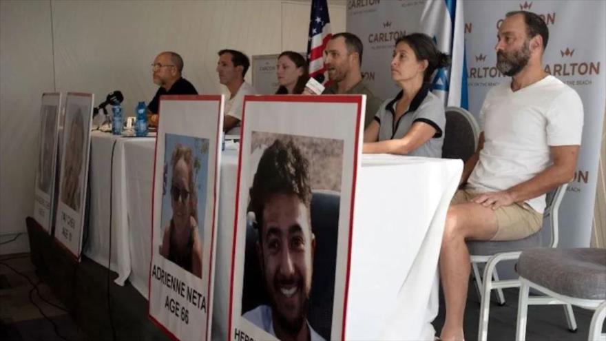 Familiares de retenidos israelíes sostienen las fotos de presos.