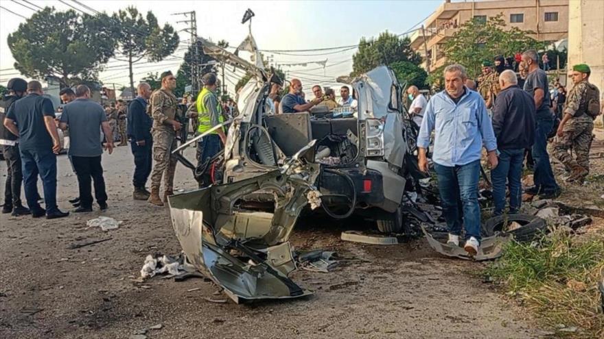 Soldados y ciudadanos libaneses se reúnen alrededor de los restos de un auto después de un ataque israelí en el valle de Bekaa, 17 de mayo de 2024.