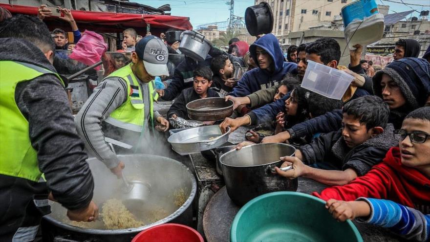 Palestinos esperan una comida caliente preparada por voluntarios en Rafah, sur de la Franja de Gaza, en medio de la creciente hambruna, 26 de enero de 2024. (Foto: Flash90)