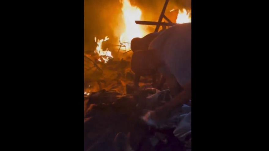 Palestinos buscan sus seres queridos tras ataque israelí contra Rafah que provocó incendio en un campamento, 26 de mayo de 2024.