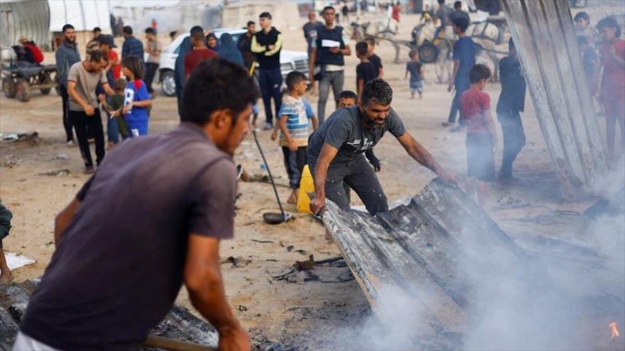 Palestinos apagan un incendio en el lugar de un ataque israelí contra campamento de personas desplazadas, en Rafah, 27 de mayo de 2024. (Foto: Reuters)