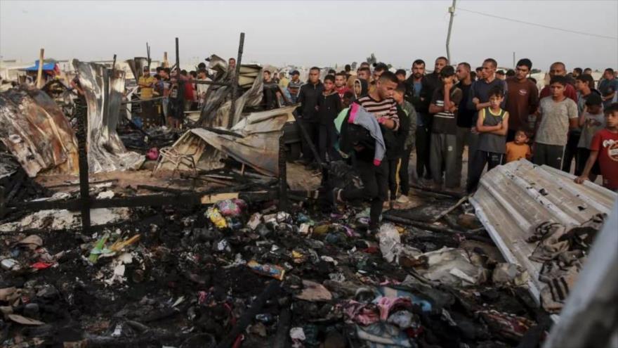 Palestinos observan la destrucción tras un ataque israelí contra los desplazados en Rafah, en la Franja de Gaza, 27 de mayo de 2024.