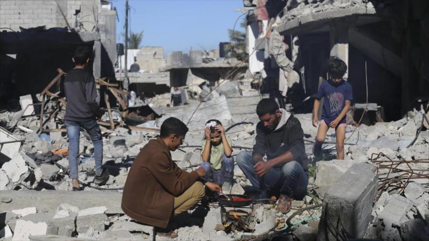 Palestinos preparan pan junto a sus casas destruidas en los ataques israelíes en Gaza, 29 de noviembre de 2023. (Foto: AP)