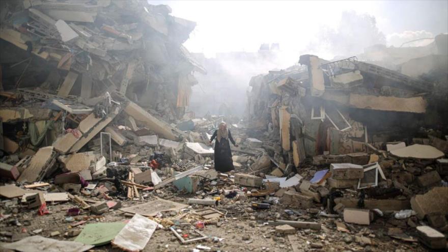 Una mujer camina entre los escombros de edificios destruidos por los ataques israelíes en el barrio de Al-Zahra en Gaza, 19 de octubre de 2023. (Foto: Getty Images)