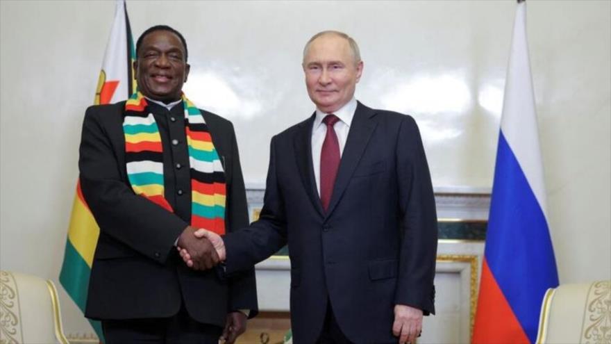 El presidente de Rusia, Vladimir Putin,(dcha.) le da la mano al presidente de Zimbabwe, Emmerson Mnangagwa, durante una reunión (SPIEF) en San Petersburgo. 6 de junio de 2024.