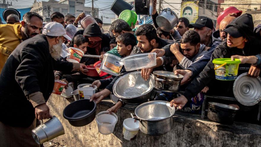 Un grupo de palestinos en la cola de recibir comida en la Franja de Gaza. 