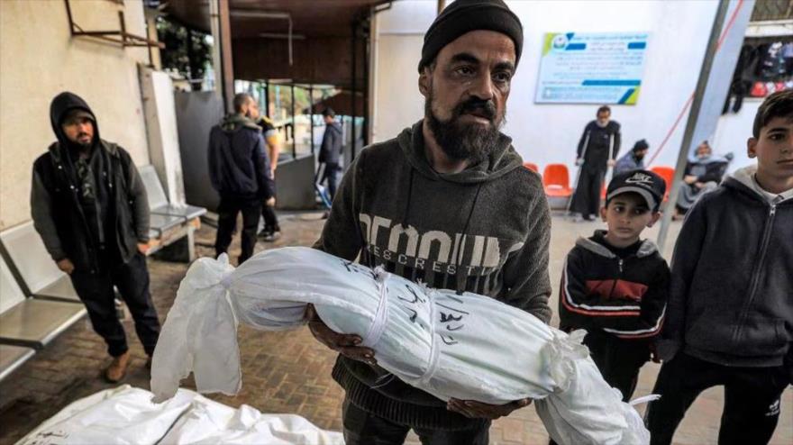 Un familiar lleva uno de los cuerpos de la familia, en la morgue del hospital al-Najar en Rafah, en el sur de Gaza, el 3 de enero de 2024. (Foto: AFP)