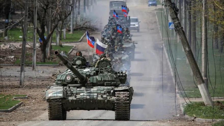 Un convoy blindado de tropas con banderas de Rusia avanza por una carretera en la ciudad portuaria sureña de Mariupol, en Ucrania, 21 de abril de 2022. (Foto: Reuters)