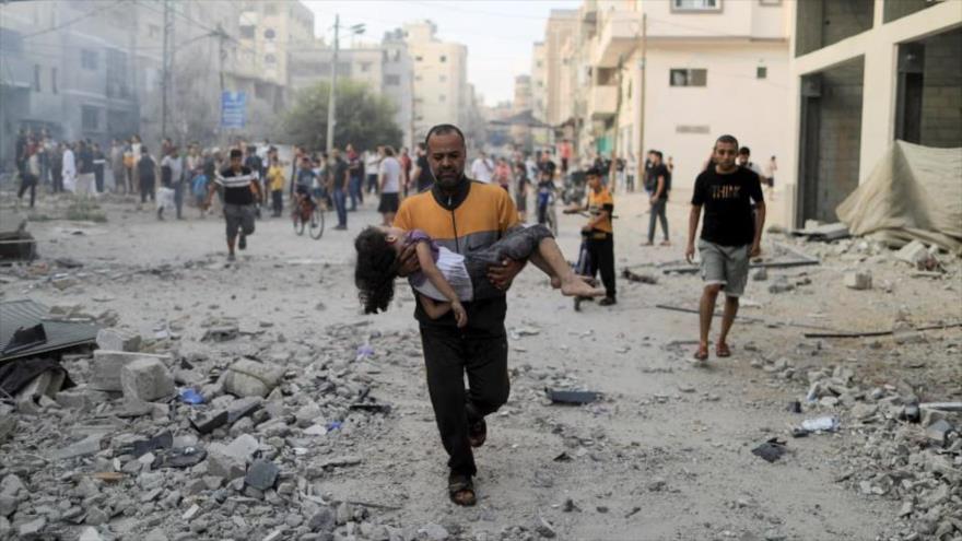 Un hombre palestino lleva a una niña herida tras un ataque israelí contra Jan Yunis, en el sur de la Franja de Gaza, 14 de octubre de 2023. (Foto: Reuters)